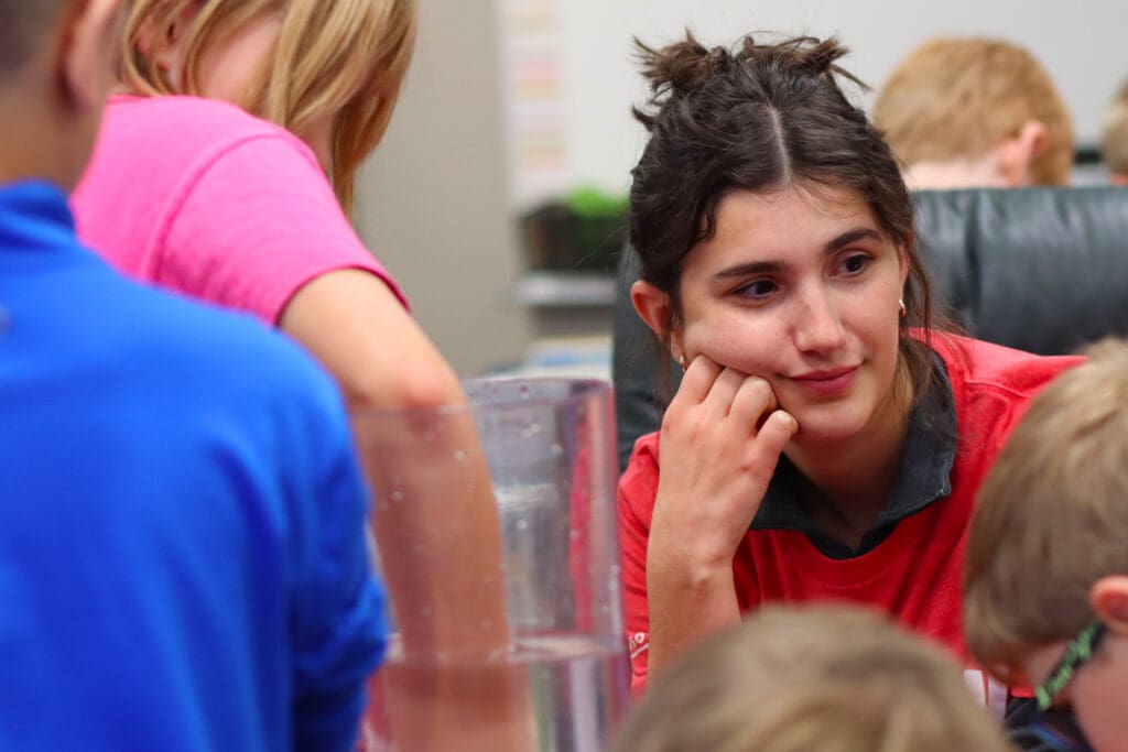 Lamp Rynearson engineer, Cassie Wolf helping students through an engineering activity