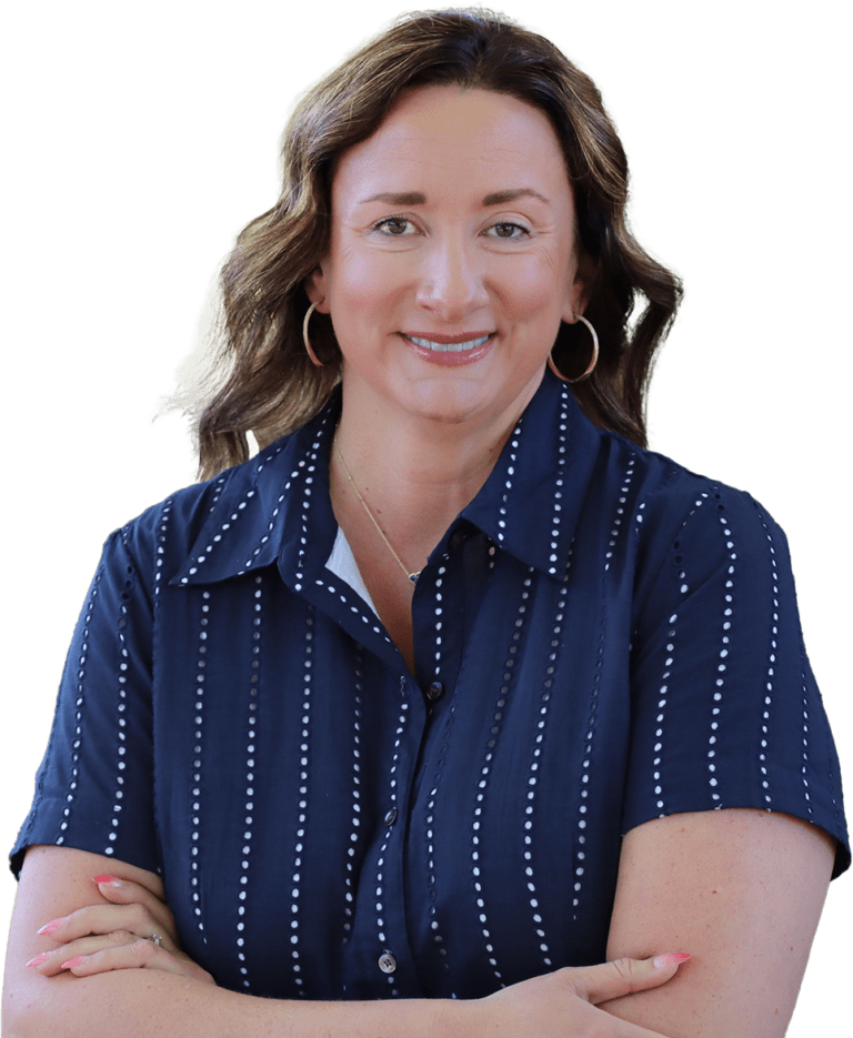 Smiling woman with arms crossed, wearing a navy dotted shirt and hoop earrings, looking at the camera.